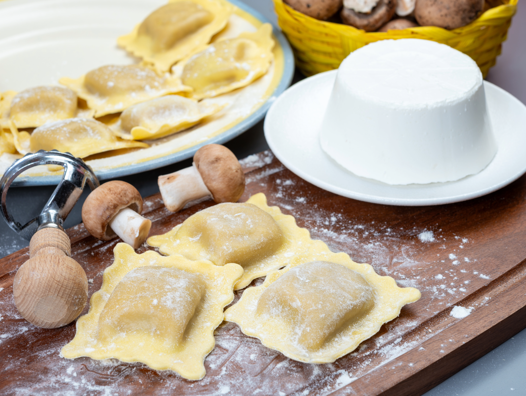 Porcini ravioli pasta squares with visible filling, dusted with flour on a board