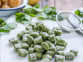 Spinach gnocchi, green potato dumplings dusted with flour