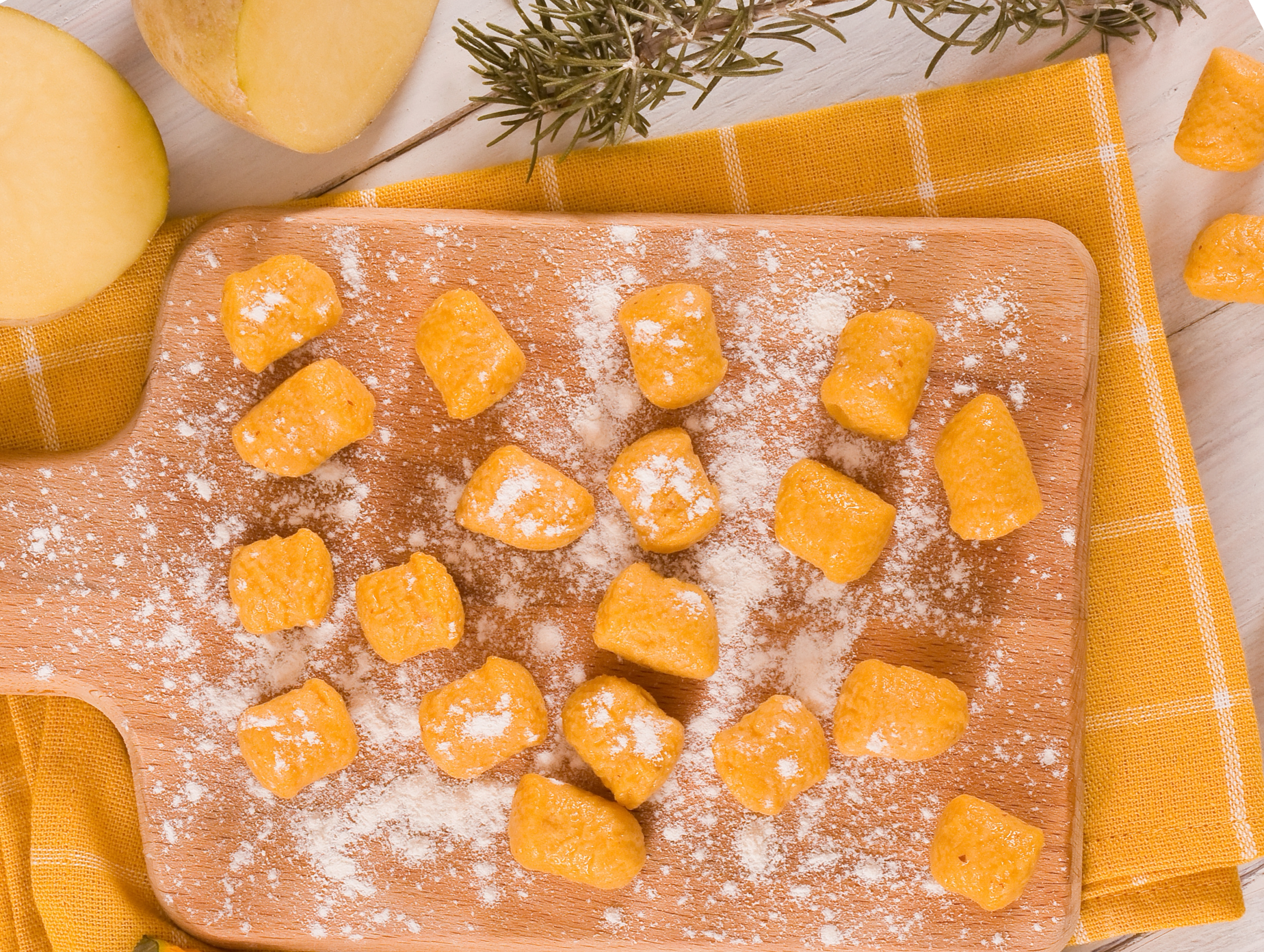 Sweet potato gnocchi on a wooden board, dusted with flour