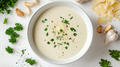 Creamy Alfredo sauce in a white bowl, topped with black pepper and chopped parsley.