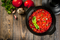 Marinara sauce in a black bowl, red tomato sauce with visible herbs