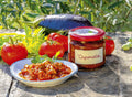 Caponata sauce jar with red lid and bowl of chunky vegetable sauce